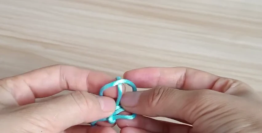 Step 3: Return the end through the small opening — 十字结
