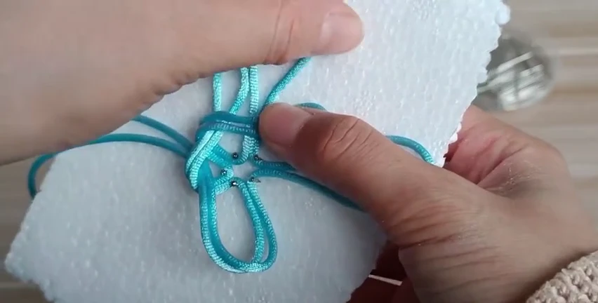 Step 2: Continue folding around the center — 五耳吉祥结